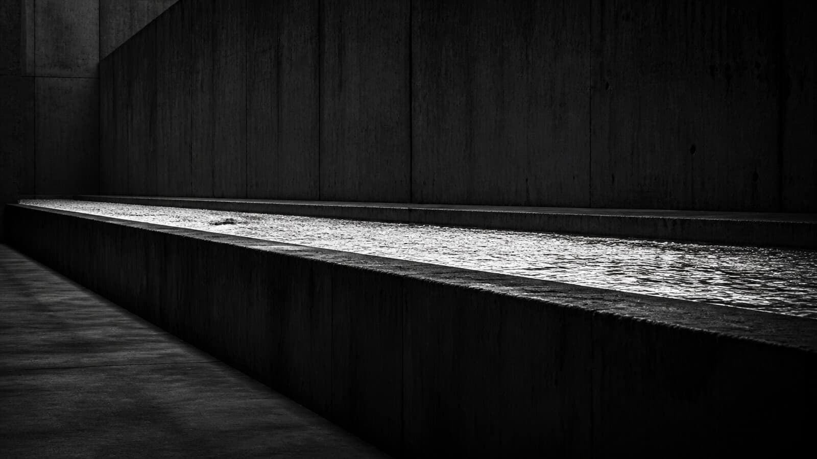 A straight concrete channel carrying water in bright light